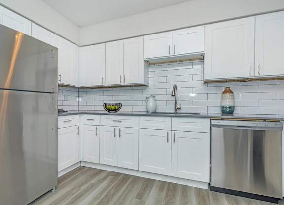 A kitchen with white cabinets and a stainless steel refrigerator.at Solara, Phoenix