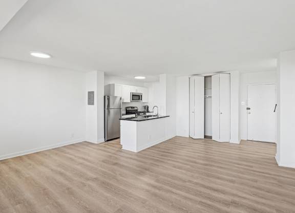 A kitchen with white cabinets and a wooden floor. at Stratford at Southern Towers, Alexandria