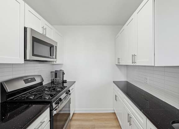 A kitchen with black countertops and white cabinets. at Stratford at Southern Towers, Alexandria, 22311