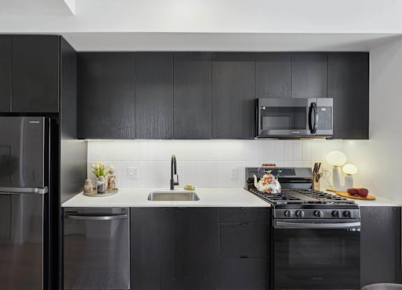 Modern kitchen with black refrigerator at Velaris Living Apartments, Colorado