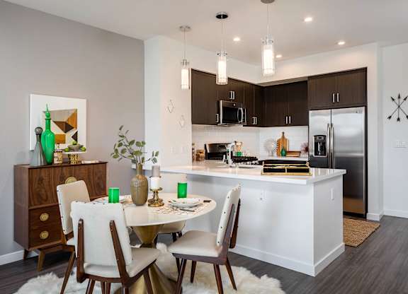 A modern kitchen with a dining table set for four.