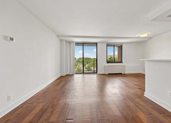 A room with wooden flooring and white walls.