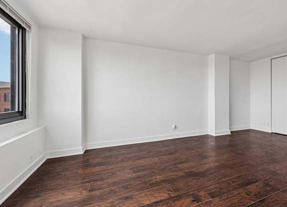 Empty room with wooden floors and white walls.