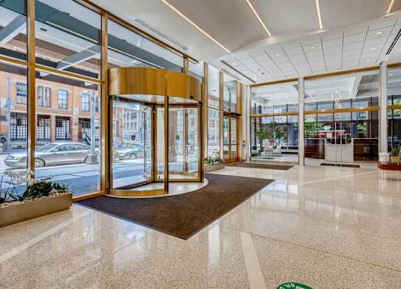 A large, open lobby with a marble floor and a view of the street outside through large windows.