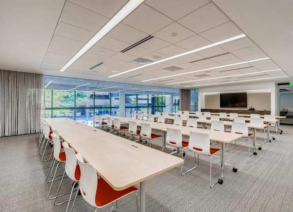 A conference room with a long table and chairs.
