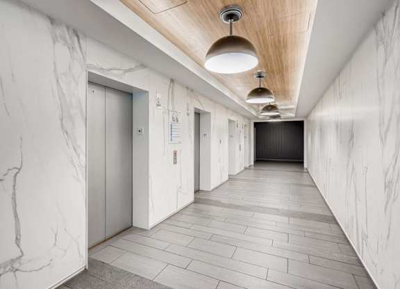 A long hallway with marble walls and a wooden ceiling.