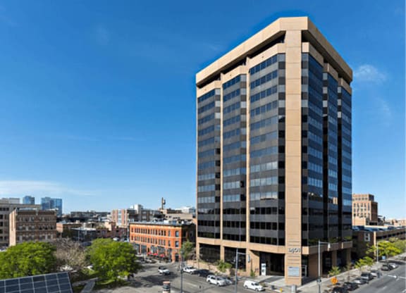 A tall building with a parking lot in front of it.
