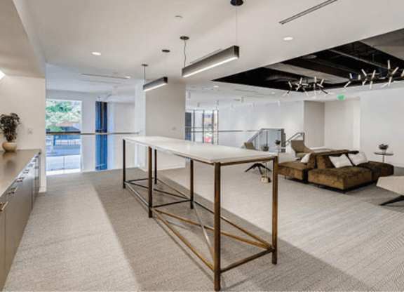 A modern kitchen with a long table and a couch.