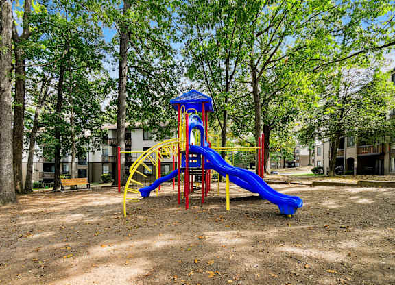 A playground with a blue slide and yellow structure.