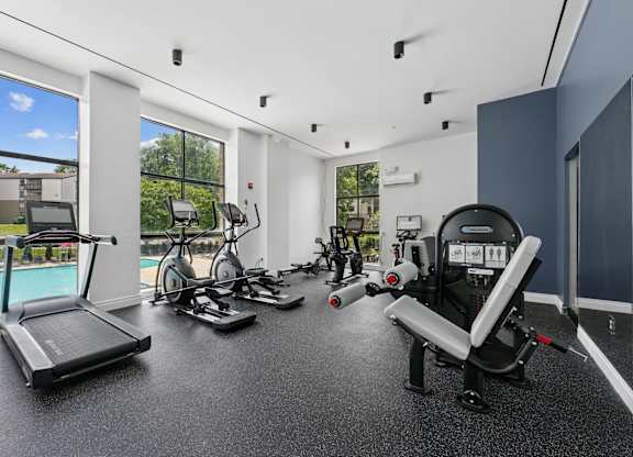 A spacious home gym with a treadmill, exercise bike, and other equipment.