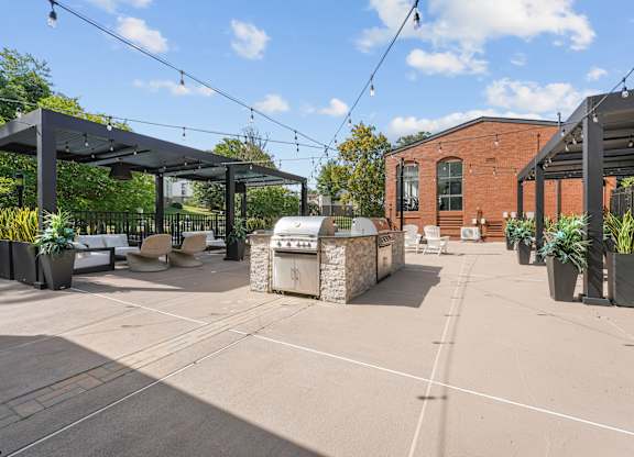 A patio area with a black awning and a brick building in the background.