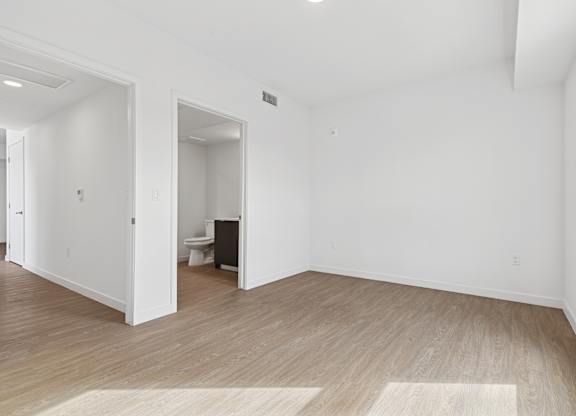 A room with wooden flooring and white walls.