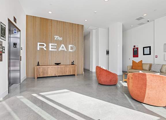 A room with a wooden panelled wall and a sign that says "The READ" on it.