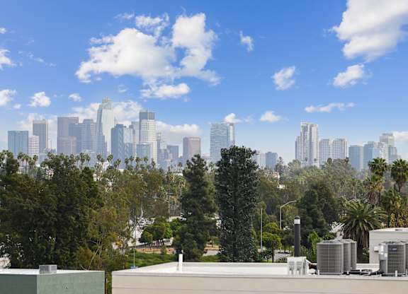 A city skyline with tall buildings and a clear blue sky.