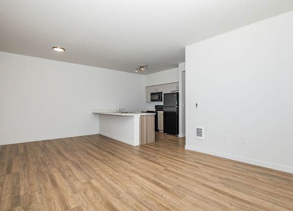 A room with a white counter and a black refrigerator.