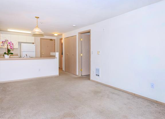 A kitchen with a sink, a refrigerator, and a counter with a vase of flowers on it.