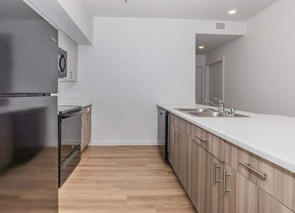 A kitchen with wooden floors and white countertops.