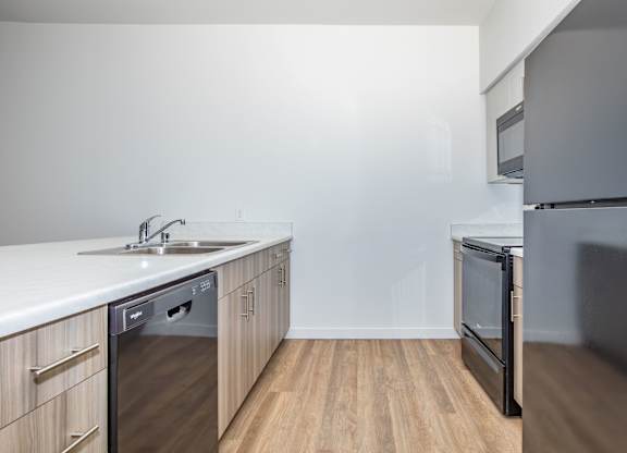 A modern kitchen with a sink, dishwasher, and oven.
