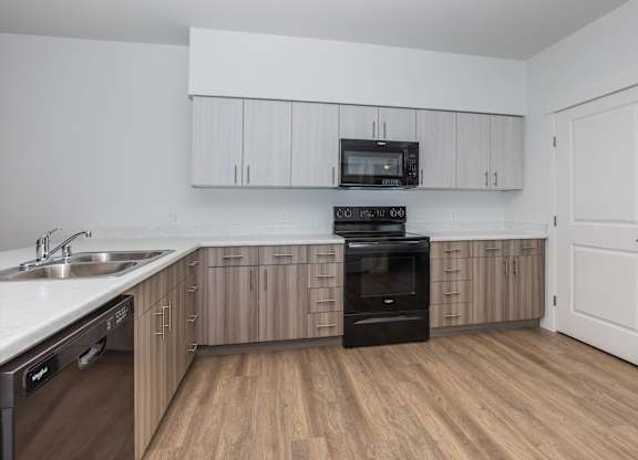 A kitchen with wooden floors and white walls.
