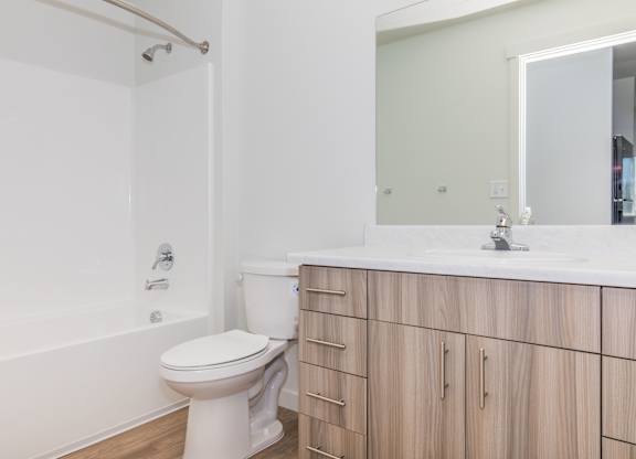 A white toilet in a bathroom with wooden cabinets.