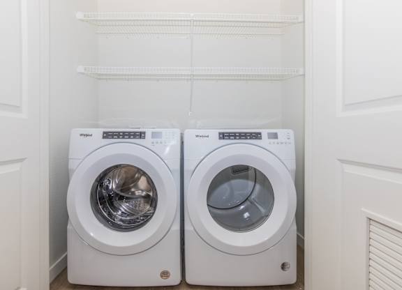 Two front loading washing machines in a small laundry room.
