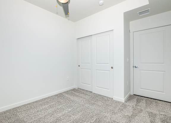 A room with two doors and a ceiling fan.