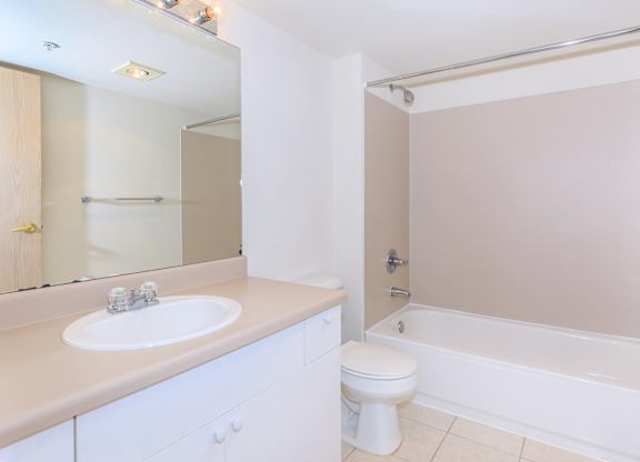 A white bathroom with a sink, toilet, and bathtub.
