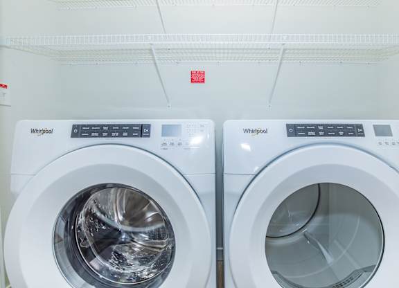 Two Whirlpool washing machines are side by side.