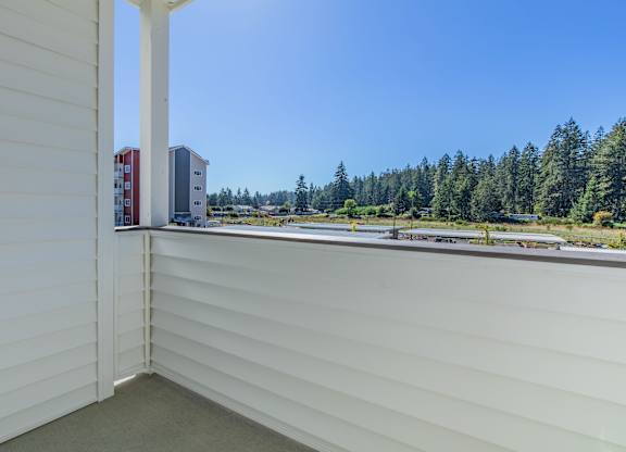 A view from a window of a white building with a red and white building in the distance.