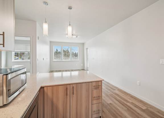 A kitchen with wooden cabinets and a microwave.