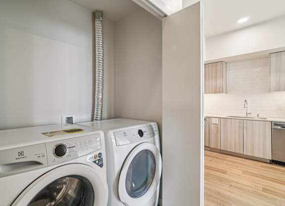 A white washing machine and dryer in a small laundry room.
