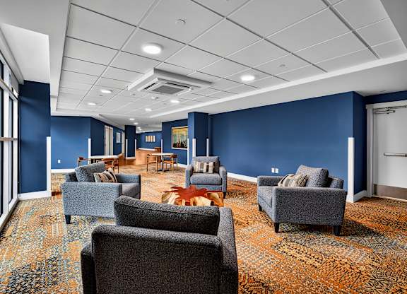 A room with blue walls and a carpet with a pattern of orange and blue.