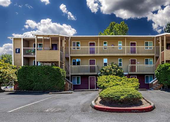 A large apartment complex with a parking lot in front.