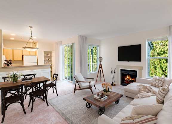 A living room with a fireplace and a flat screen TV mounted on the wall.