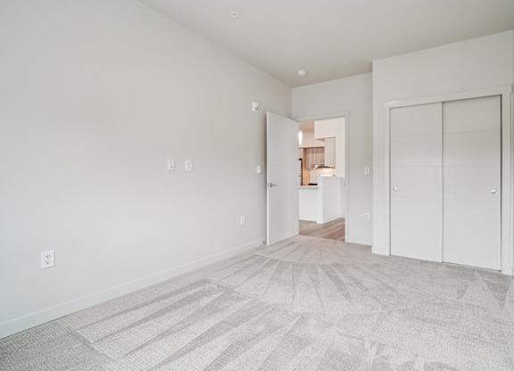 A room with a carpeted floor and white walls.