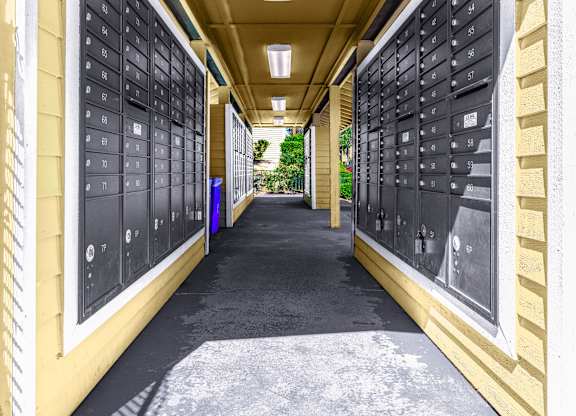 A long hallway with mailboxes on the wall.