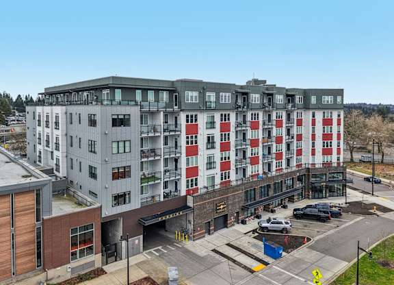 A large multi-story building with a parking lot in front.