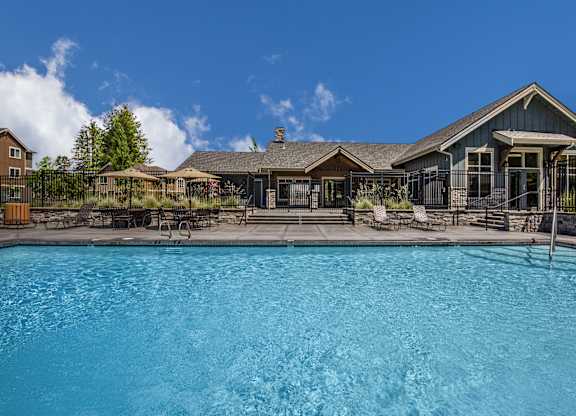 A large swimming pool in front of a house.