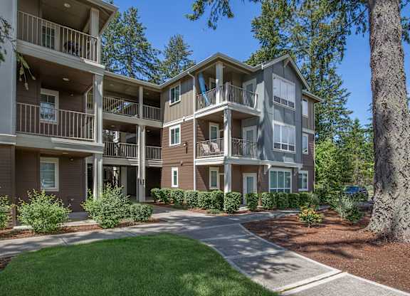 A large apartment complex with a green lawn in front.
