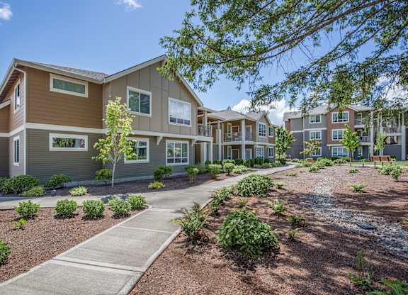 A modern apartment complex with a well-maintained landscaped courtyard.