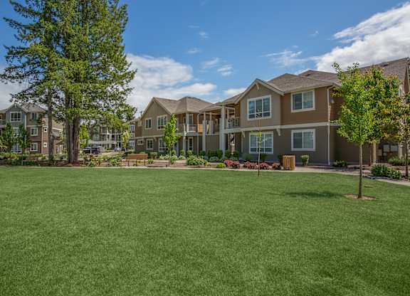 A grassy area in front of apartment buildings.