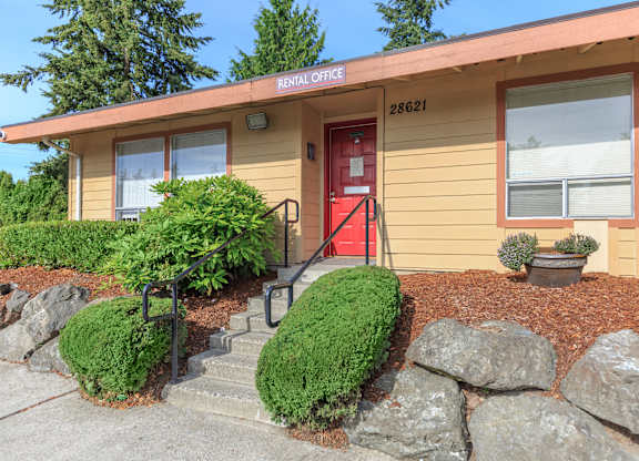 A building with a red door and a sign that says "Rental Office" on the top.