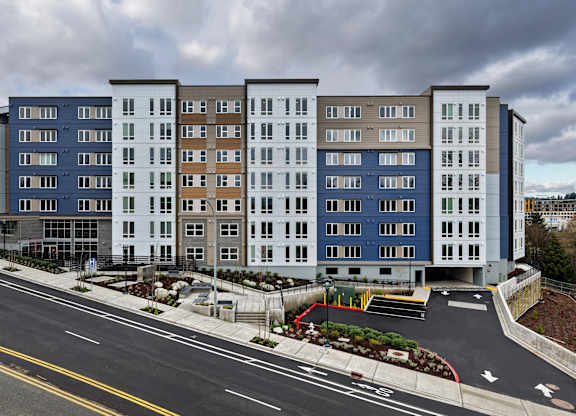 A large multi-story building with a parking lot in front.
