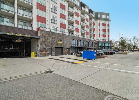 A parking garage is in front of a multi-story building.