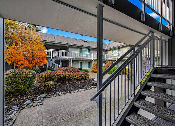 A staircase with a metal railing leads to a building.