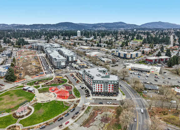 A cityscape with a large building in the center and a road running through it.
