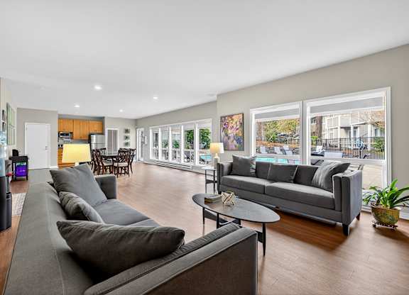A living room with a grey couch and a black speaker.