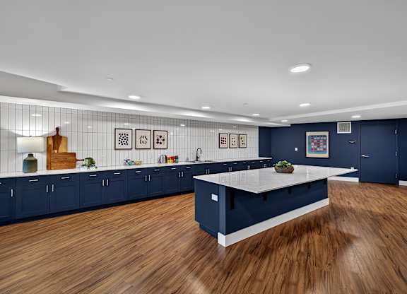 A kitchen with dark blue cabinets and a white island.