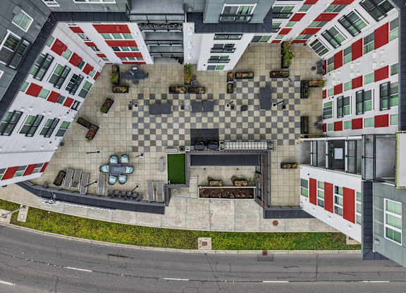 A top down view of a courtyard surrounded by buildings with a checkerboard pattern.