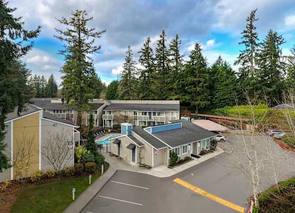 A parking lot is in front of a building with a yellow and blue roof.